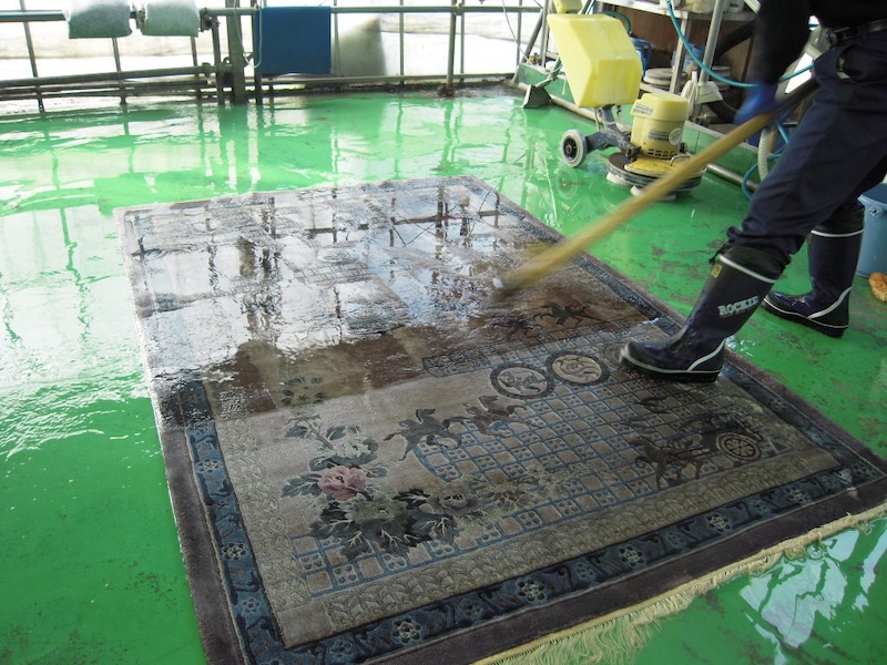 絨毯を広げて洗っている様子