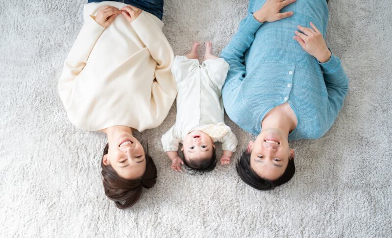 絨毯に寝転ぶ家族